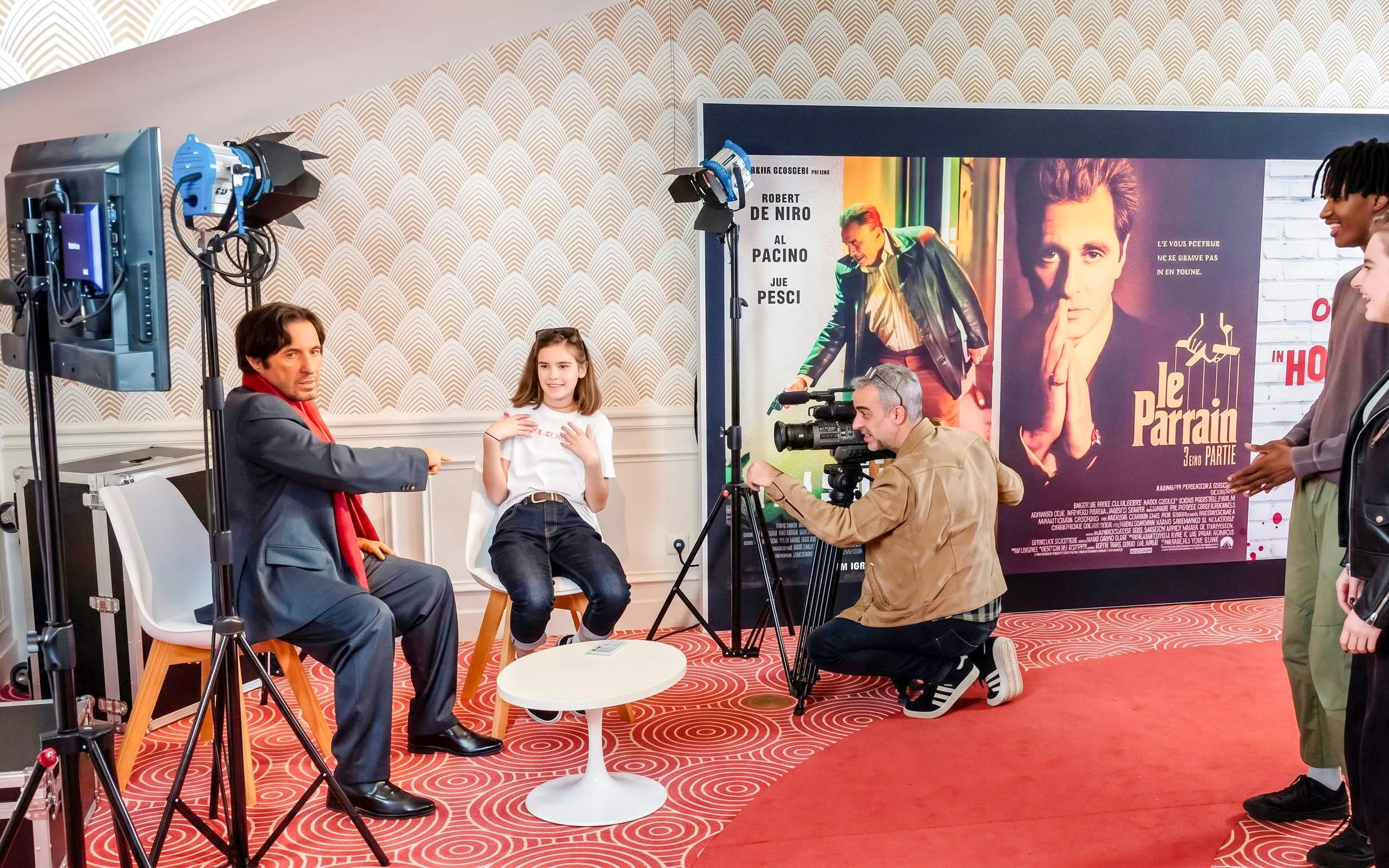 Grévin Wax Museum visitors interacting with wax figure and film set display.