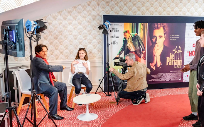 Grévin Wax Museum visitors interacting with wax figure and film set display.
