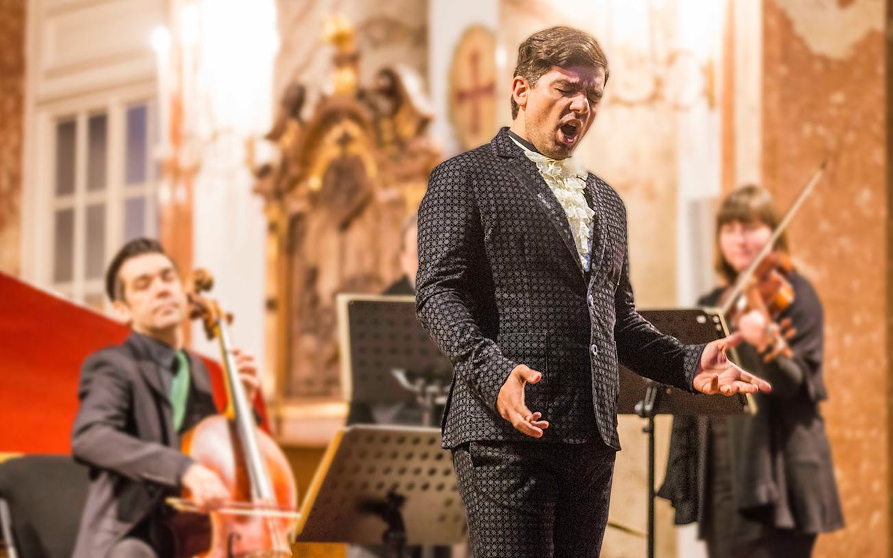 Musicians performing Vivaldi's Four Seasons at Karlskirche, Vienna, with audience in view.