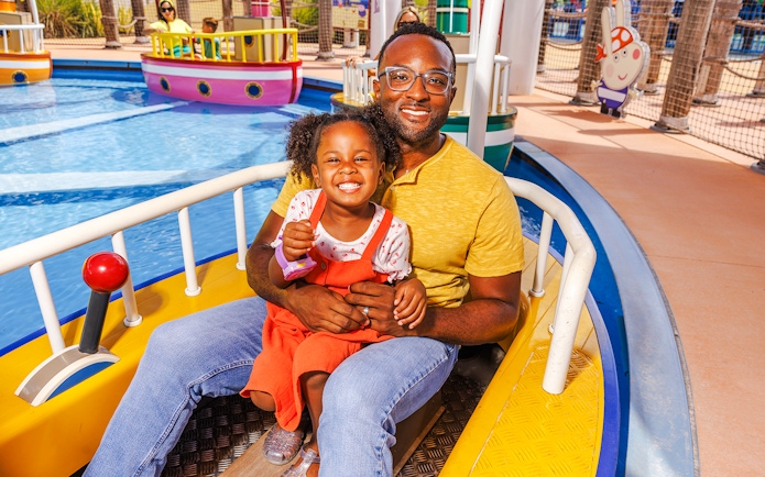 Father and daughter enjoying a boat ride at Peppa Pig Theme Park, Florida.