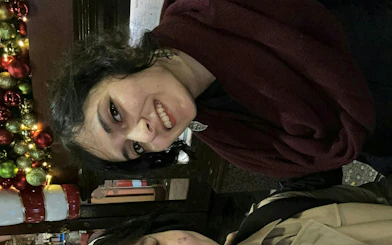 Smiling person near festive decorations during Manchester Ghost Hunt tour.