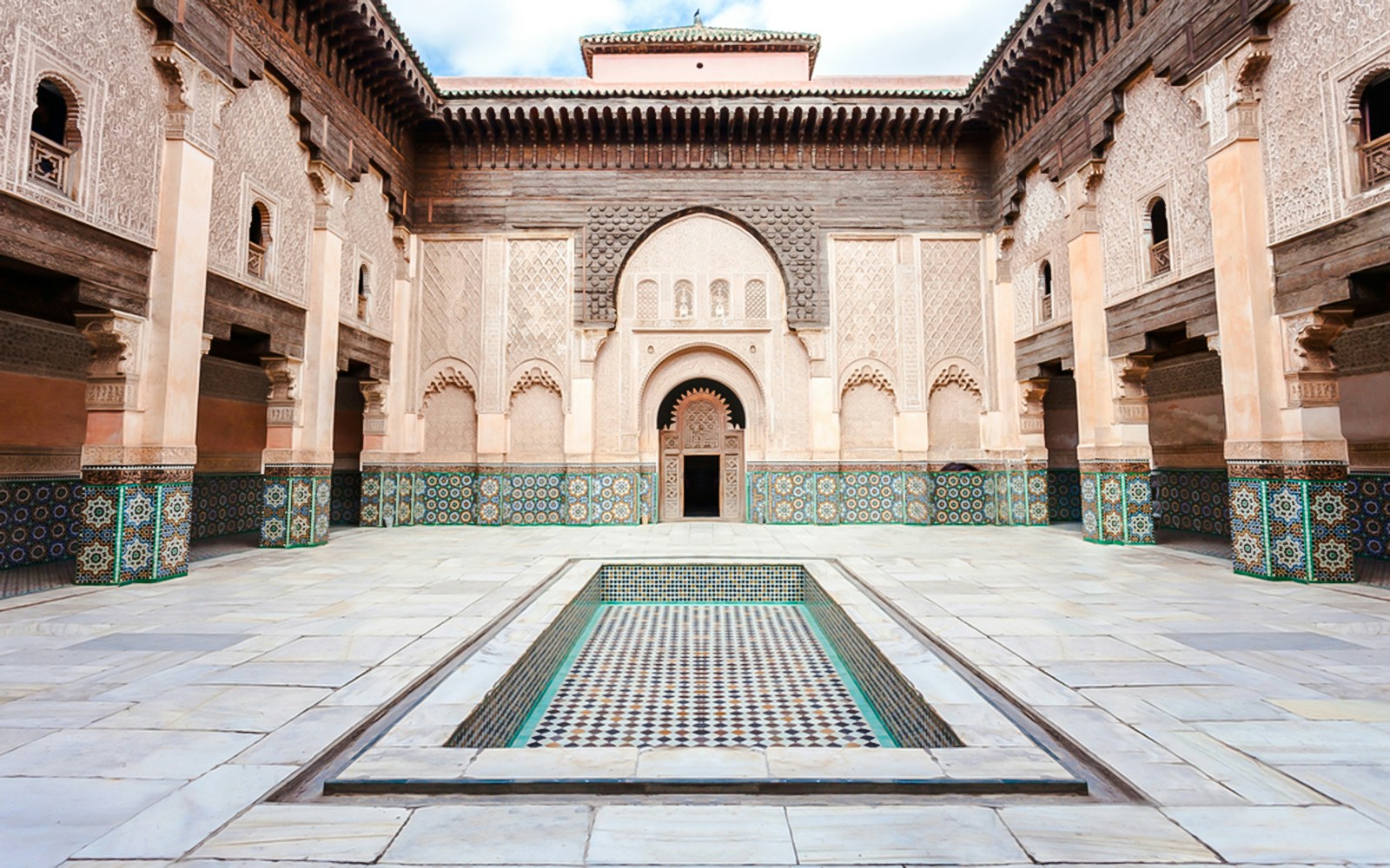 Ben Youssef Madrasa courtyard with intricate tilework in Marrakech, Morocco.