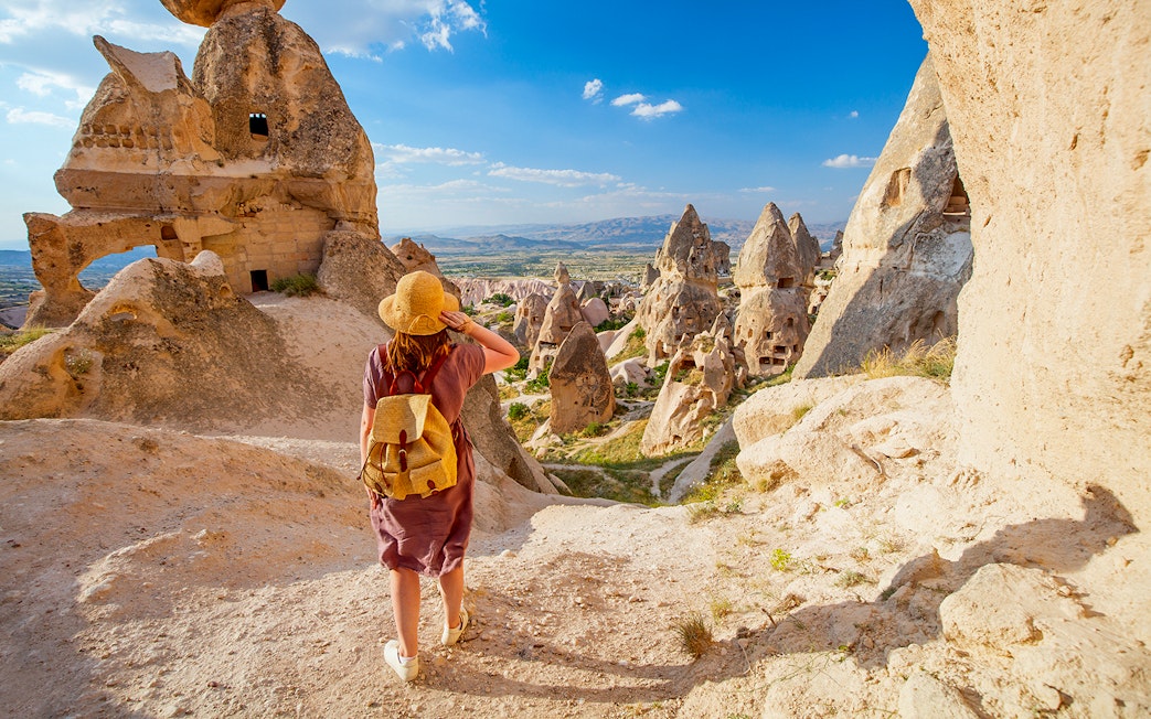 Traveler exploring rock formations in Gerome Valley, Cappadocia.