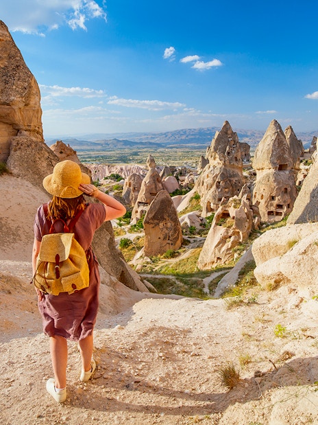 Traveler exploring rock formations in Gerome Valley, Cappadocia.