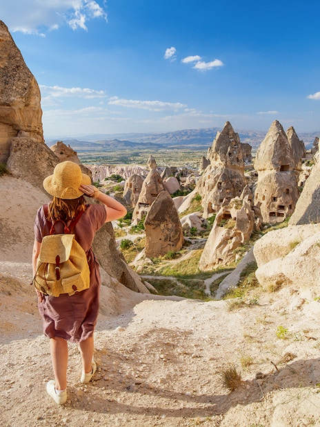 Traveler exploring rock formations in Gerome Valley, Cappadocia.