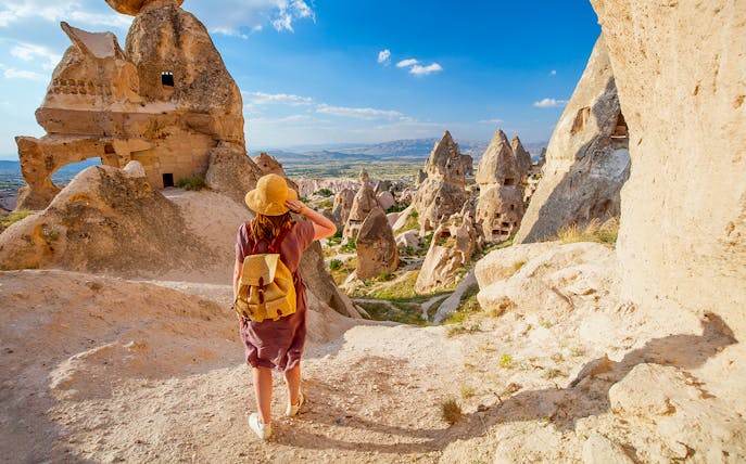 Traveler exploring rock formations in Gerome Valley, Cappadocia.