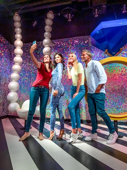 Visitors taking a selfie with a wax figure at Madame Tussauds Dubai.