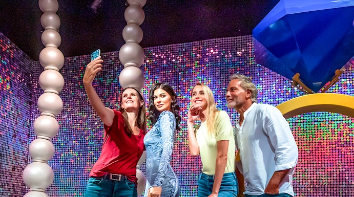 Visitors taking a selfie with a wax figure at Madame Tussauds Dubai.