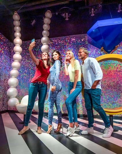 Visitors taking a selfie with a wax figure at Madame Tussauds Dubai.