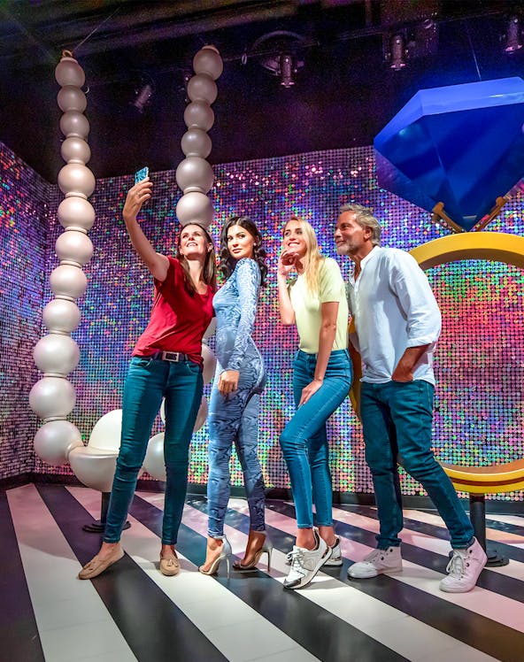 Visitors taking a selfie with a wax figure at Madame Tussauds Dubai.