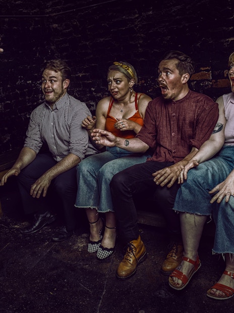 Visitors react to a witch's hands reaching out at York Dungeon's Curse of the Witch experience.