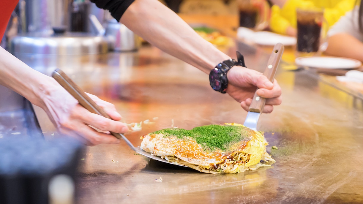 A person cooking Okonomiyaki