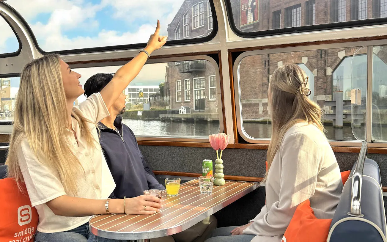Haarlem sightseeing cruise with passengers viewing historical buildings through boat windows.
