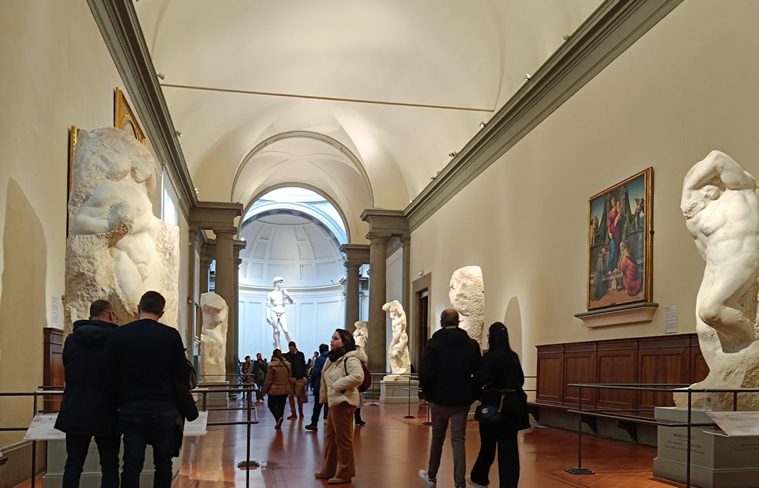 Visitors viewing Michelangelo's unfinished sculptures in the Hall of the Prisoners, Accademia Gallery.