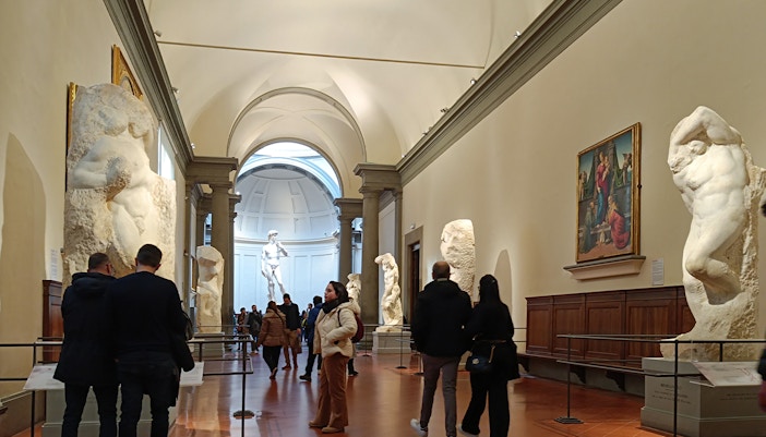 Visitors viewing Michelangelo's unfinished sculptures in the Hall of the Prisoners, Accademia Gallery.