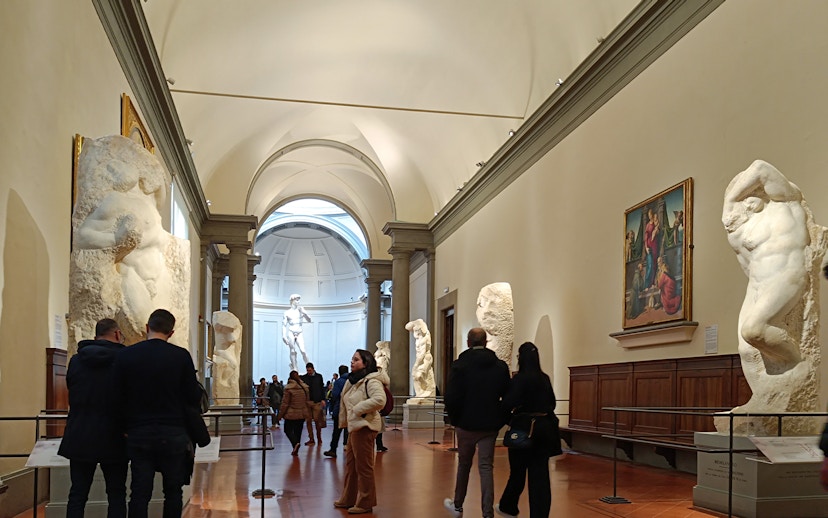 Visitors viewing Michelangelo's unfinished sculptures in the Hall of the Prisoners, Accademia Gallery.