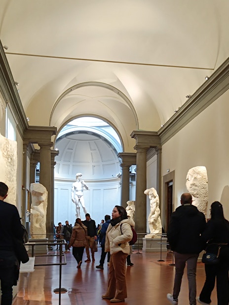 Visitors viewing Michelangelo's unfinished sculptures in the Hall of the Prisoners, Accademia Gallery.