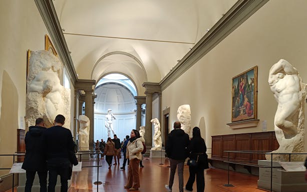 Visitors viewing Michelangelo's unfinished sculptures in the Hall of the Prisoners, Accademia Gallery.