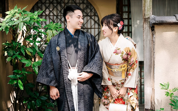 Couple in traditional kimono posing in a Japanese garden.