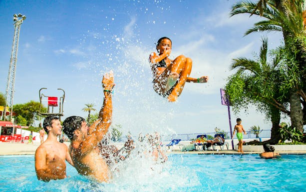 Child being tossed in pool at Illa Fantasia water park, Barcelona.