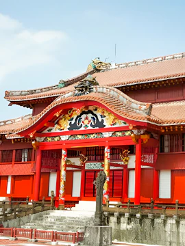 Shurijo Castle Park entrance with traditional red and gold architecture in Okinawa, Japan.