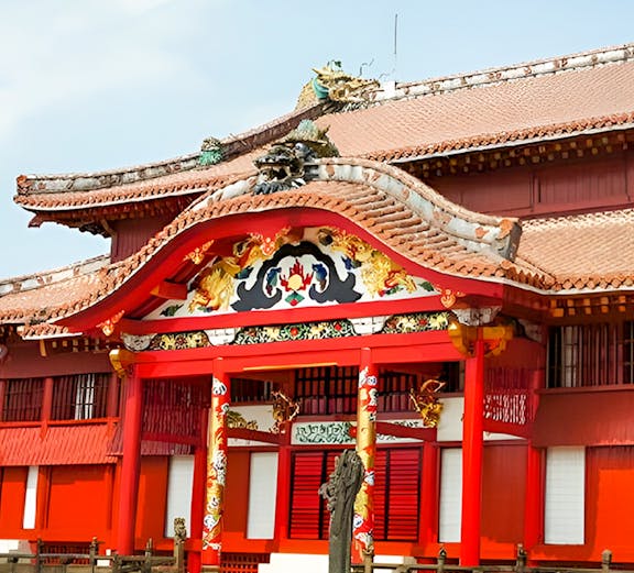 Shurijo Castle Park entrance with traditional red and gold architecture in Okinawa, Japan.