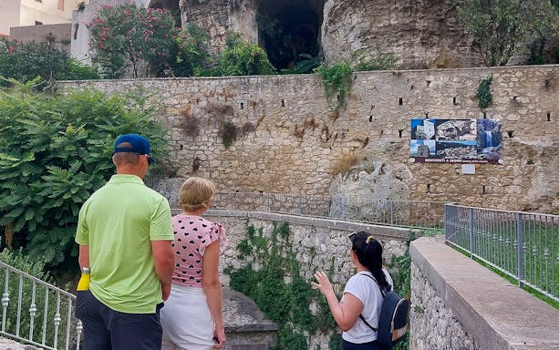 Tourists exploring ancient stone walls in Anglona during a guided tour from Castelsardo.