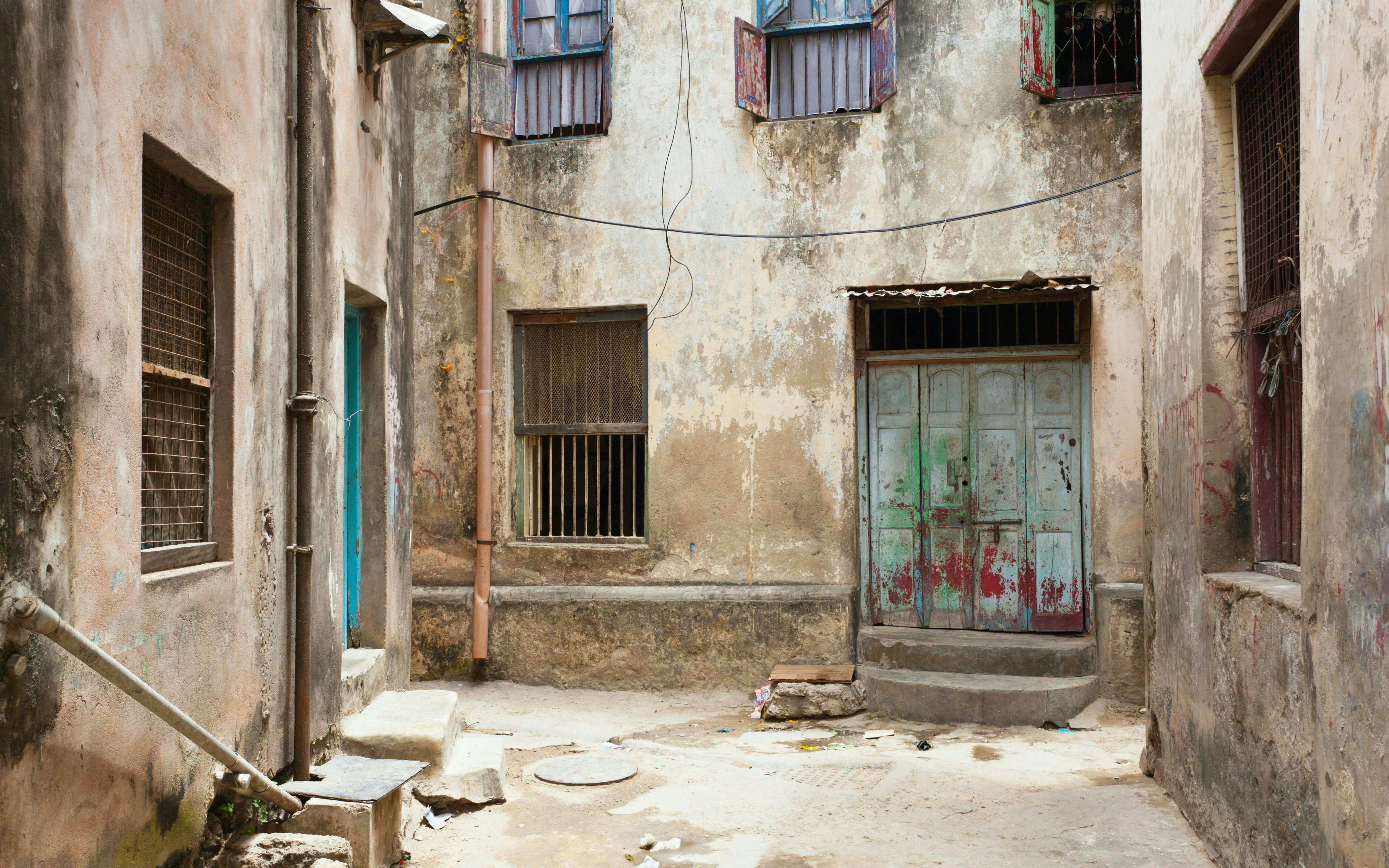 Narrow alleyway with weathered buildings in Mombasa Old Town, Kenya.