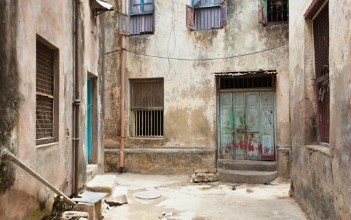 Narrow alleyway with weathered buildings in Mombasa Old Town, Kenya.