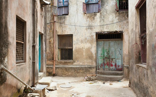 Narrow alleyway with weathered buildings in Mombasa Old Town, Kenya.