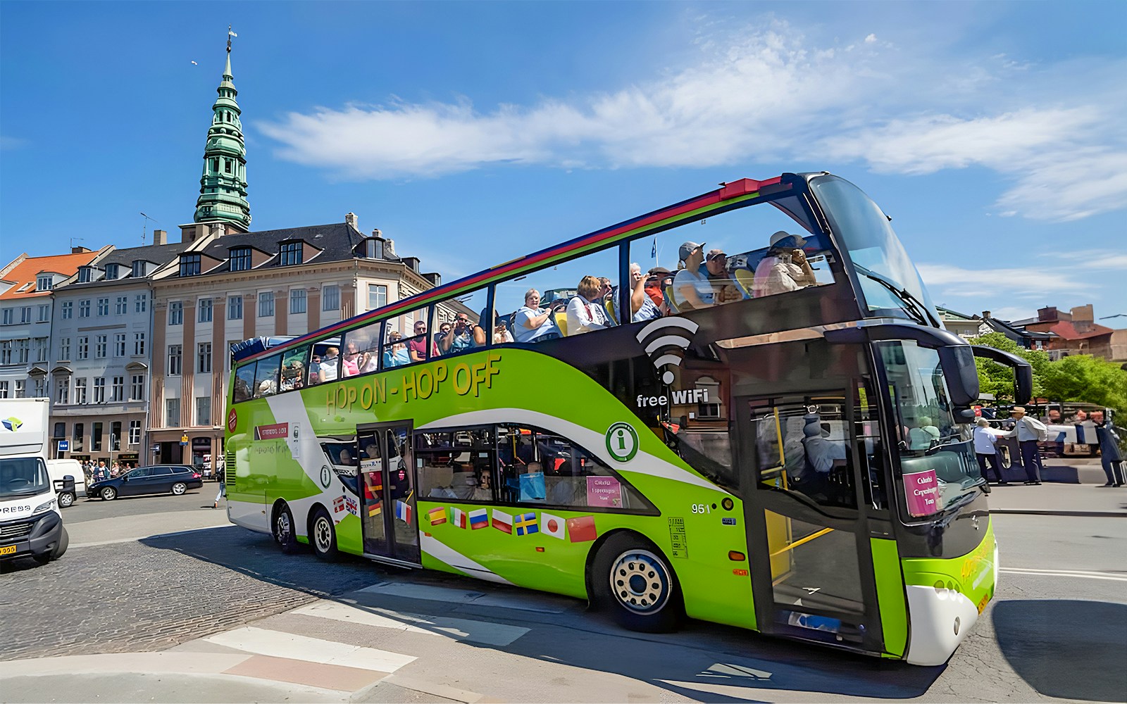 Copenhagen hop-on hop-off bus and canal cruise near colorful Nyhavn buildings.