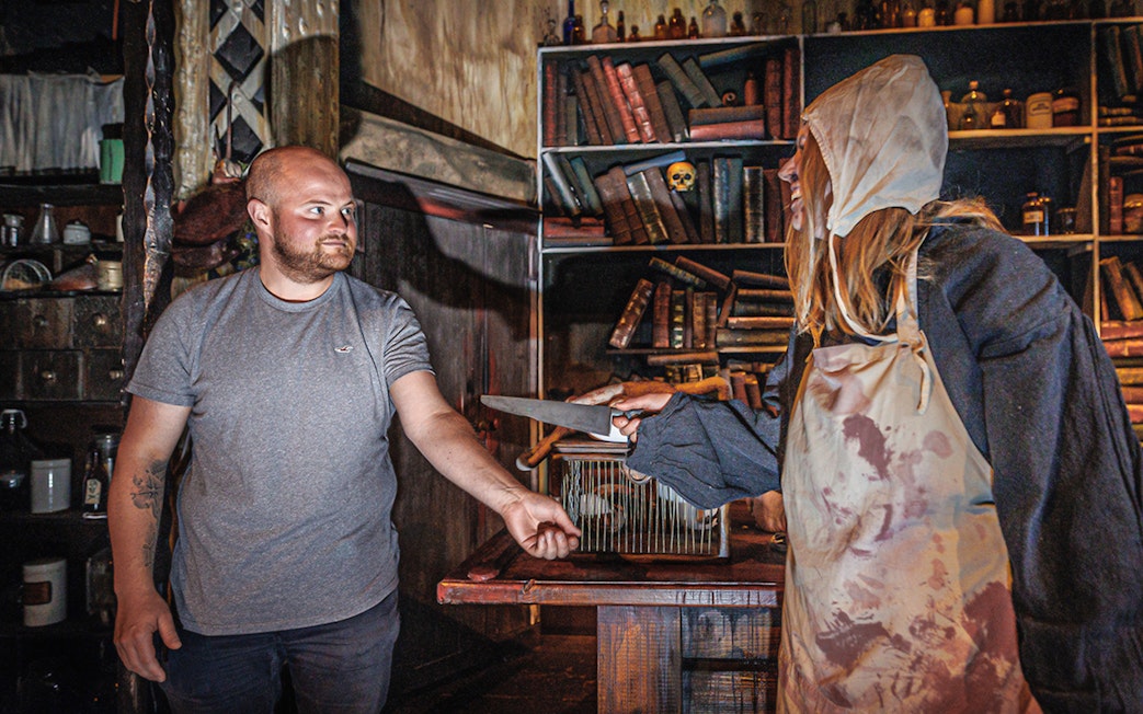 Man interacting with plague doctor in Hamburg Dungeon scene.