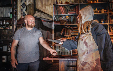 Man interacting with plague doctor in Hamburg Dungeon scene.