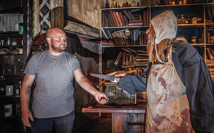 Man interacting with plague doctor in Hamburg Dungeon scene.