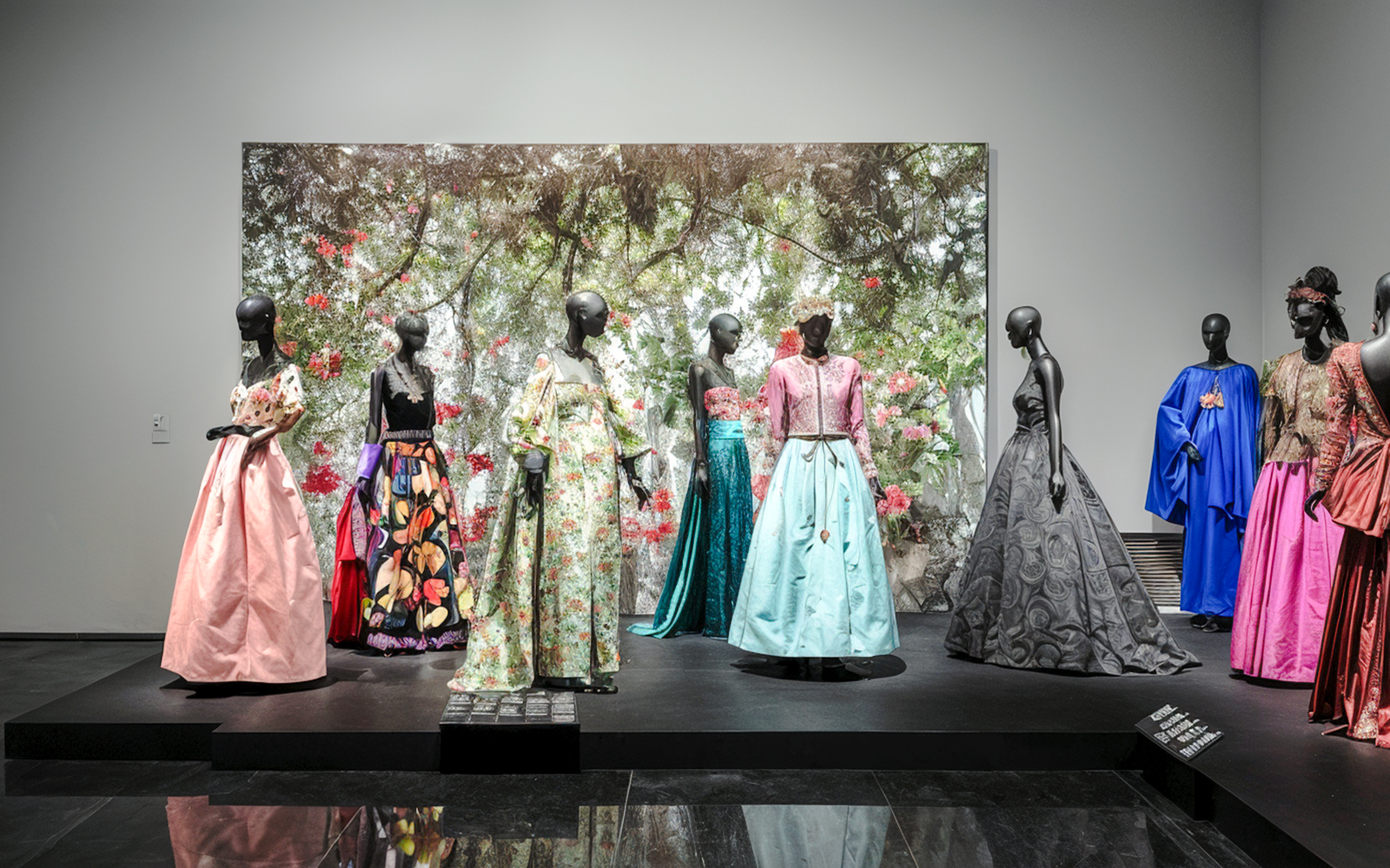 Fashion exhibit at YSL Museum in Marrakech showcasing colorful designer dresses.