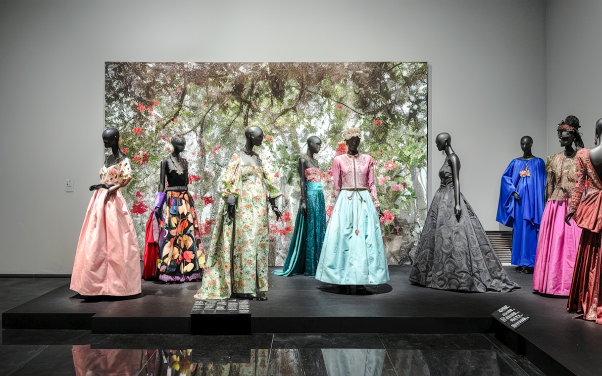 Fashion exhibit at YSL Museum in Marrakech showcasing colorful designer dresses.