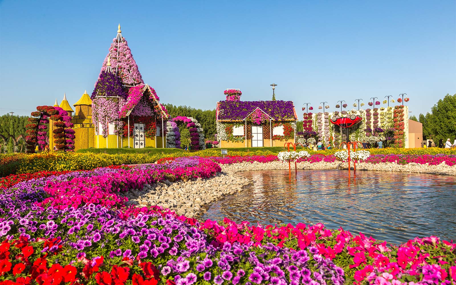 Flower-covered structures by a lake at Love Lake, Dubai.