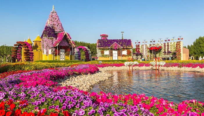 Flower-covered structures by a lake at Love Lake, Dubai.