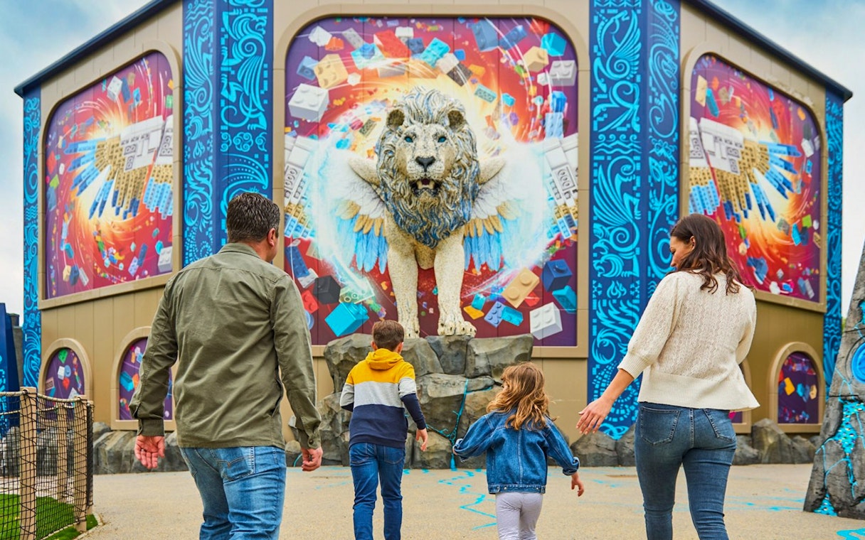 Family approaching a winged lion sculpture at LEGOLAND® Windsor Resort.