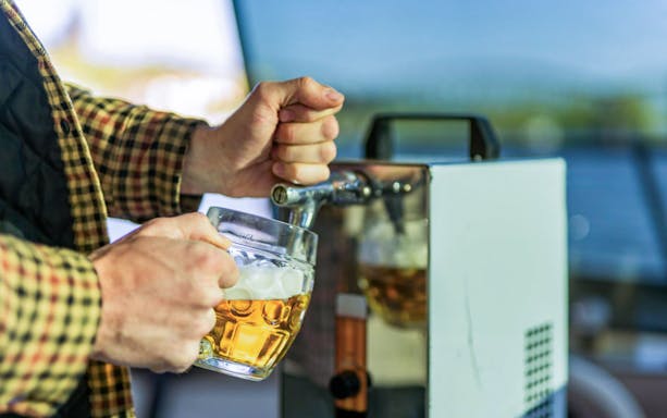 Pouring beer from a tap on Prague VIP YachtBoat ONE cruise.