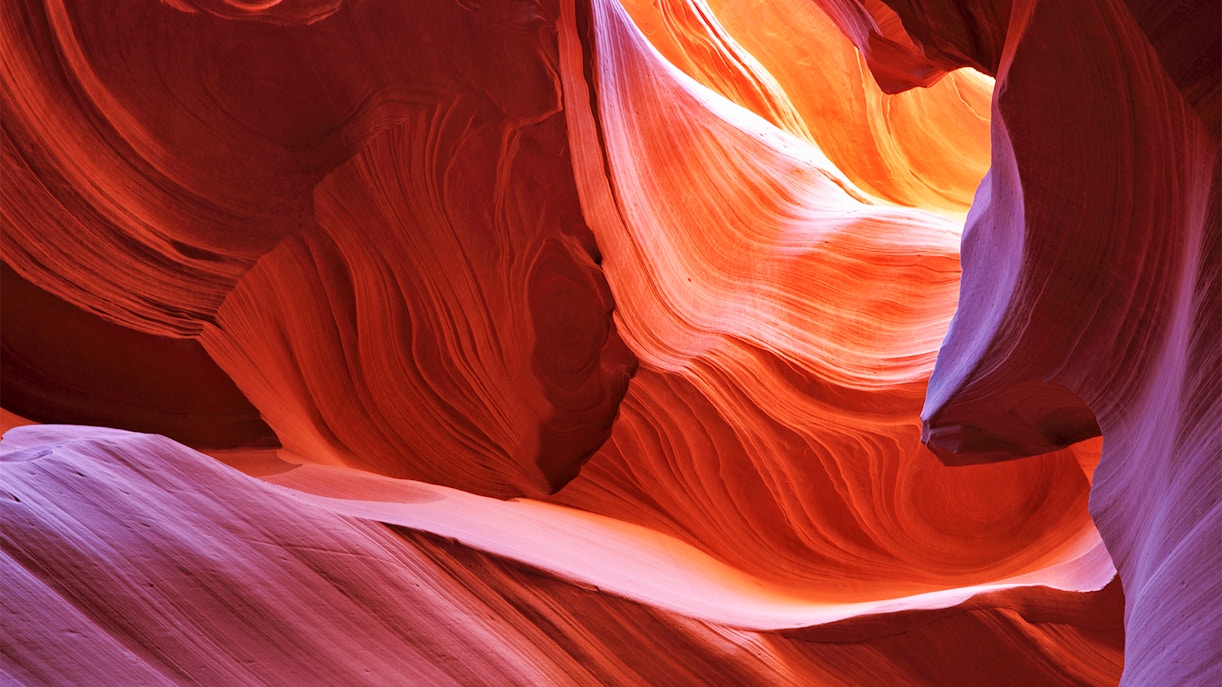 Antelope Canyon's swirling red rock formations illuminated by sunlight.