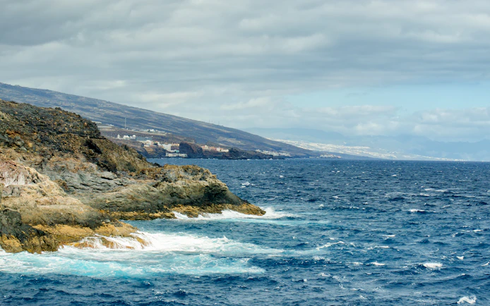 Rocky coastline with ocean waves along Tenerife's southwest shore.