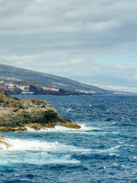 Rocky coastline with ocean waves along Tenerife's southwest shore.