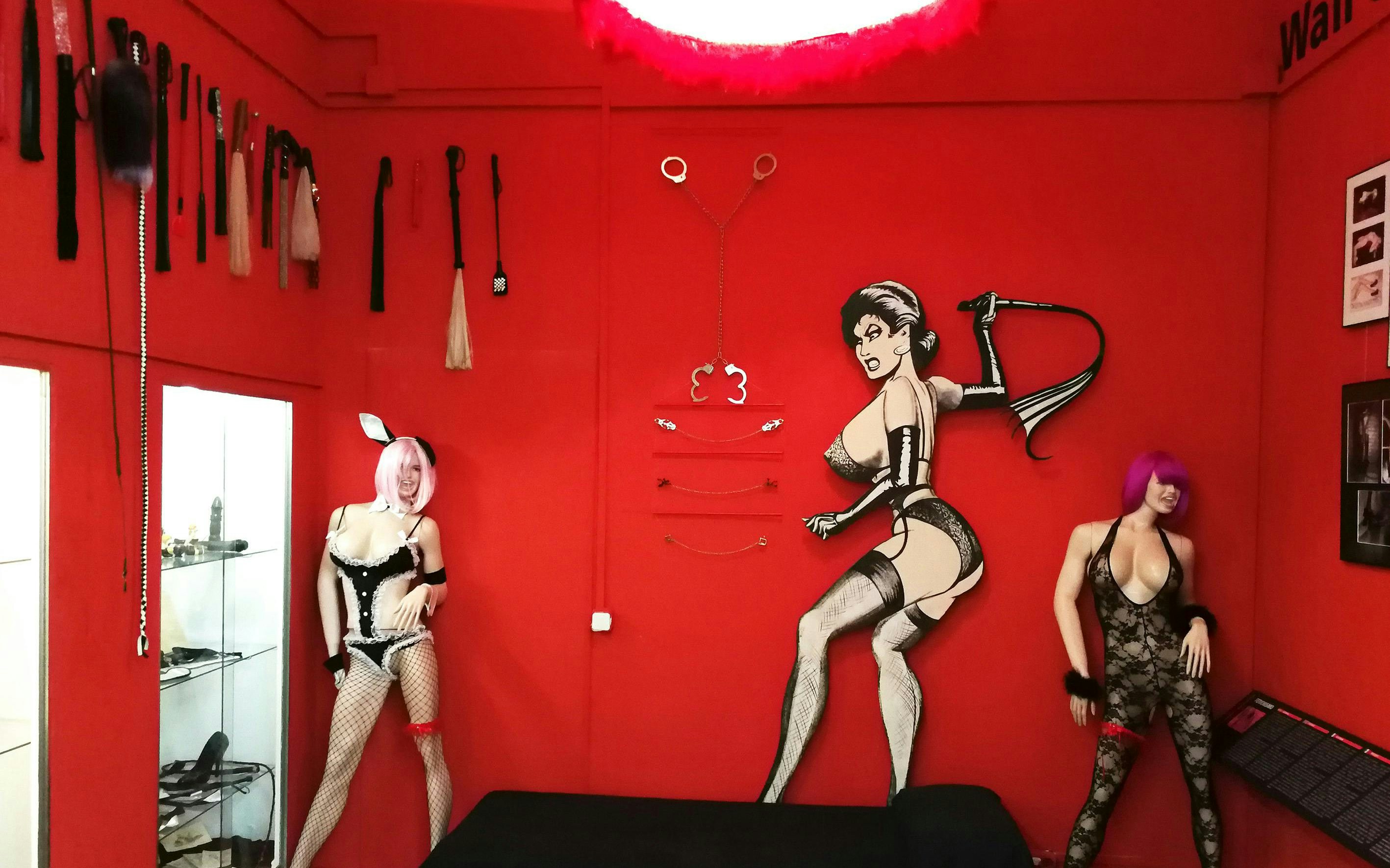 Fetish room with mannequins and BDSM gear at Erotica Museum Barcelona.