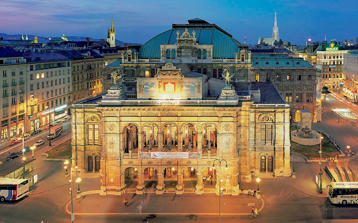 Vienna State Opera illuminated at night, venue for Mozart concert.