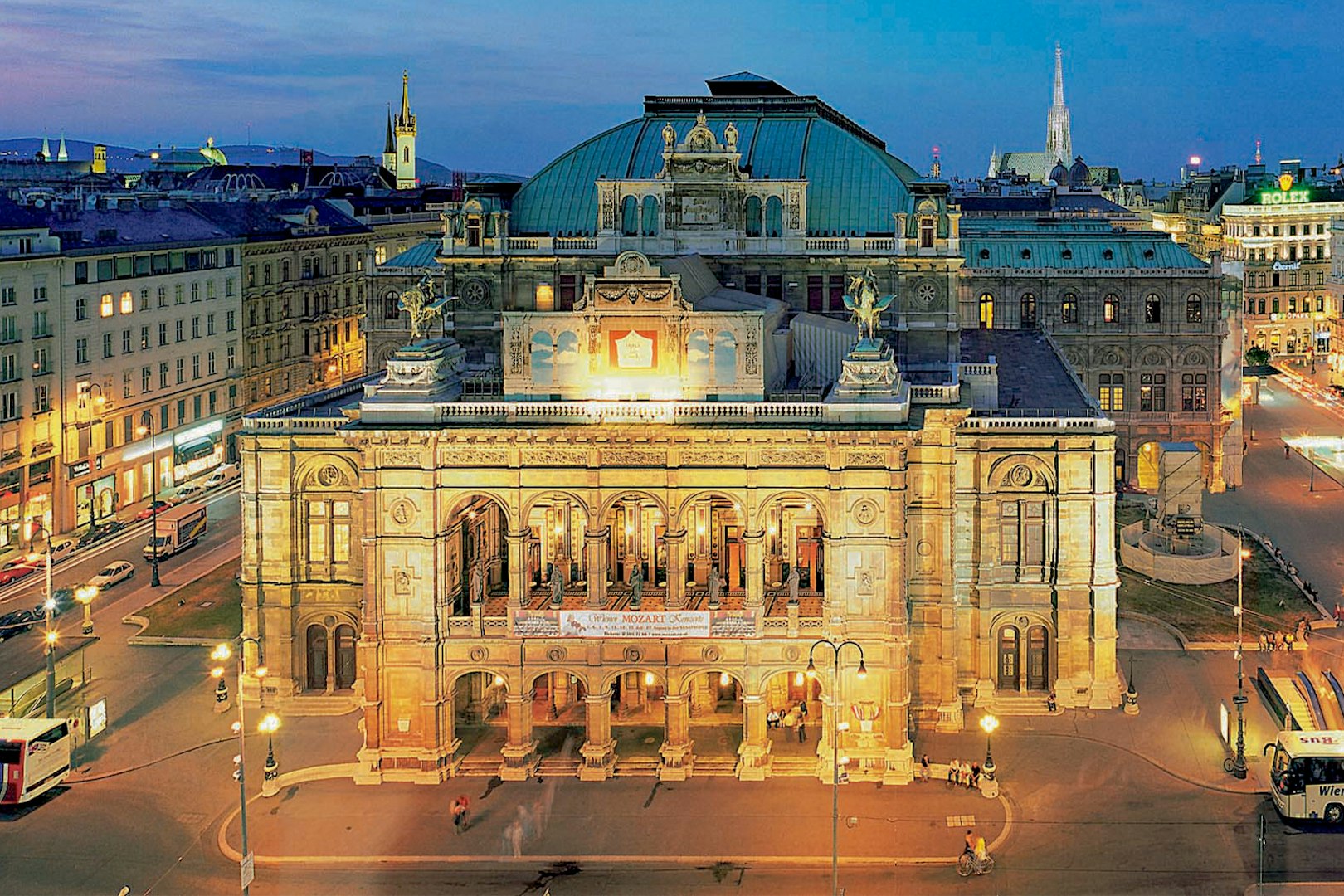 Vienna State Opera illuminated at night, venue for Mozart concert.
