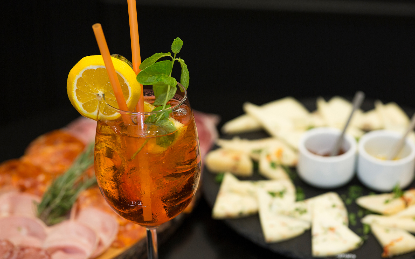Traditional Italian aperitif with prosciutto, mortadella, cheese, and Aperol Spritz in Italy.