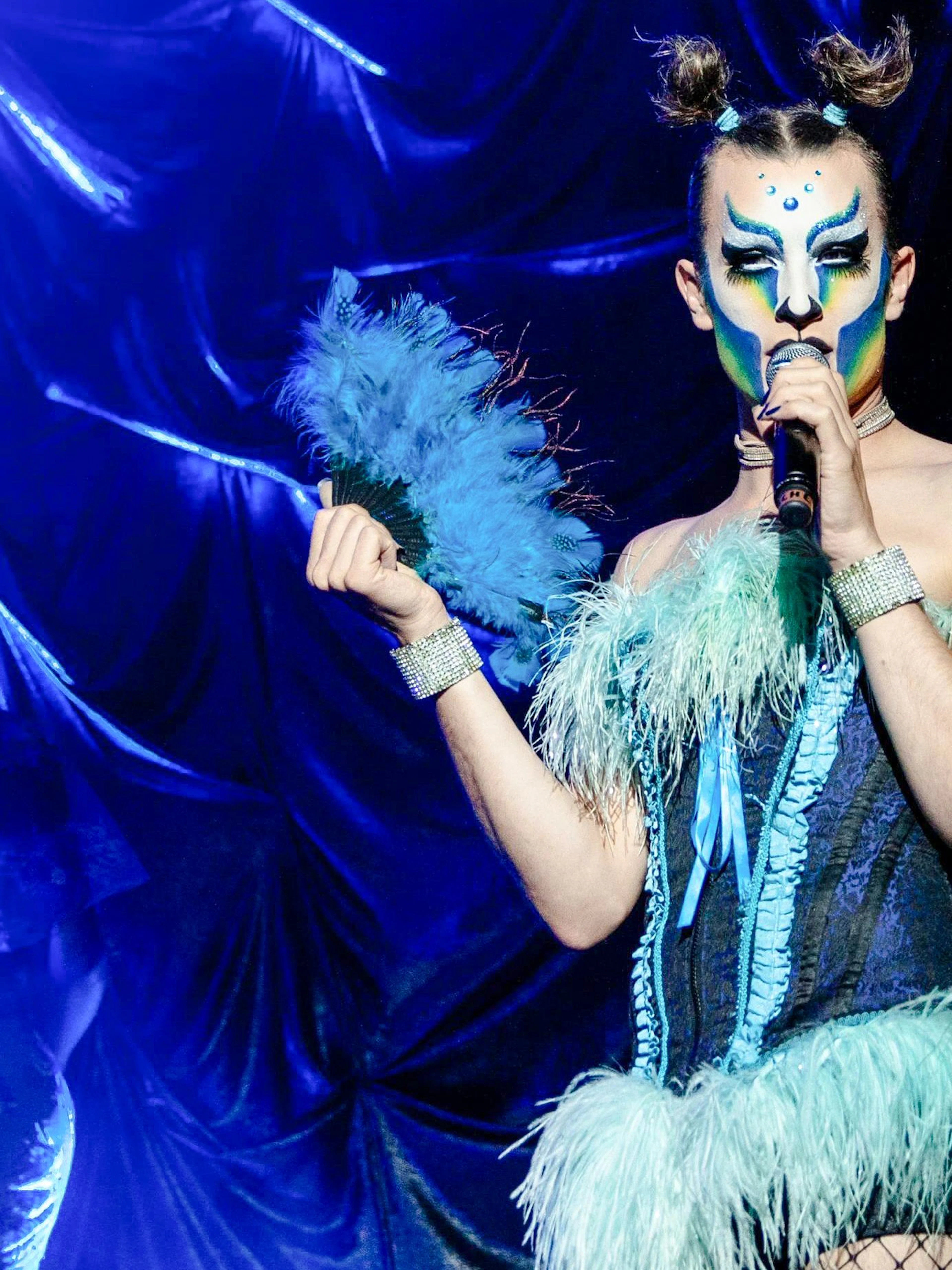 Performer in vibrant costume at Madame Arthur cabaret show, Paris.
