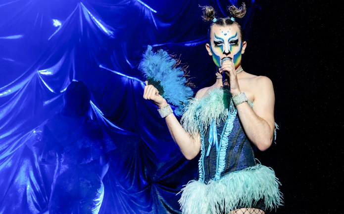 Performer in vibrant costume at Madame Arthur cabaret show, Paris.