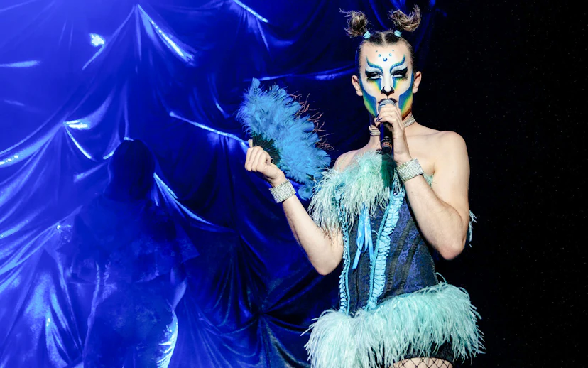 Performer in vibrant costume at Madame Arthur cabaret show, Paris.